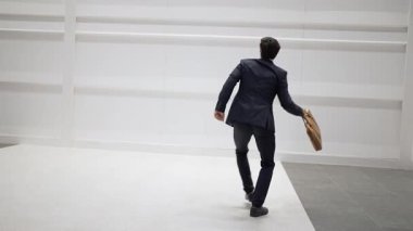 Proje yöneticisi, beyaz arkaplanlı canlı müziğe geçerken başarı projesini kutlamak için dans ediyor. Beyaz arka planda dans ederken çantasını tutan yetenekli bir iş adamı. Uzayı kopyala Sevinçli..