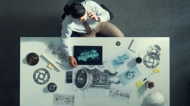 Tablet ekran elektrik jeneratörüne bakarken akıllı mühendisin türbin motor yapısı hakkında yöneticiyi aramasının yukarıdan aşağıya hava görüntüsü. Teknisyen, jet motoru hakkında ekiple konuşuyor. Hizalama.