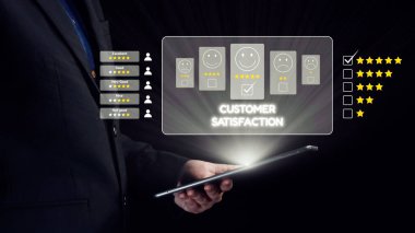 Bir işadamı, müşteri memnuniyeti ölçümlerini bir tablette inceleyerek, yıldız reytinglerini ve geri bildirim simgelerini vurgulayarak, müşteri sezgilerinin iş dünyasındaki önemini gözler önüne seriyor. Dörtgen