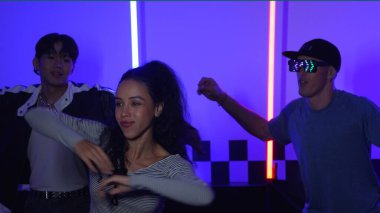 Gündelik gömlekli, gözlüklü, neon ışıkla dans eden farklı insanlar. Gece kulübünde dans ederken kameraya bakıp sokak dansı yapan çok kültürlü break dansçı. Mutluluk.