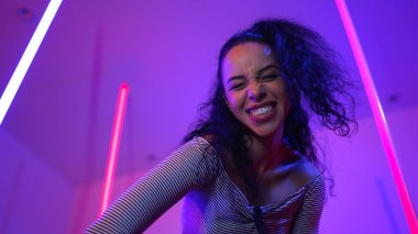 Latin dansçıların kameraya bakıp şehrin pop müziğiyle dans ettiği düşük açılı kamera. Profesyonel çekici hipster, mor veya neon ışıklı hip hop şarkısına geçiyor. Şık bir kumaş. Mutluluk.