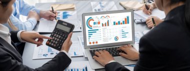 İş zekası ve veri analizi kavramı. Analizci ekibi laptop ekranında finansal veri analizi üzerinde çalışıyor. Etkili iş stratejik planlama için pazarlama göstergesi olarak. İçgörü