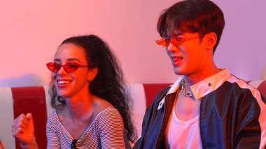 Liderli ya da neonlu ışıkla dans eden Asyalı adamla İspanyol kadının yakın çekimi. Profesyonel sokak dansçısı serbest stile ve canlı müziğe taşınırken gözlük ve bez takıyor. Mutluluk.