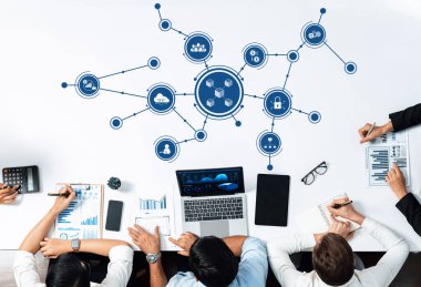 Bir grup iş adamı, teknolojiyle birlikte verileri analiz ederek modern ofis ortamında çeşitli görsel çizelgeler oluşturmaya çalışıyor. Dostluk