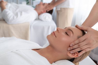 Kafkasyalı çift stres önleyici kafa masajının keyfini çıkarıyor ve lüks otellerde ya da otel spa salonlarında gündüz kaplıcalarında yüz güzelliği eğlencelerini şımartıyor. Sessiz.