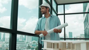 Gökdelen manzarasına bakarken yürüyen profesyonel mimar mühendisi. Masaya yerleştirilmiş ev modeliyle pencereye bakarken yetenekli proje yöneticisi proje planını tutuyor. Tasarım. İzleme