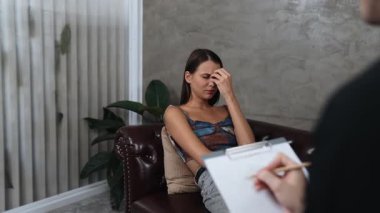 Savunmasız, stresli, genç bir hasta, ofisteki zihinsel tedavi sırasında duygusal travma, endişe ve akıl hastalıklarını psikiyatriste aktarıyor. Psikolojik danışma seansı. Düzenle