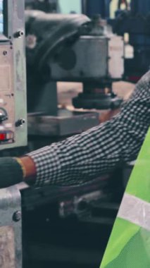 Fabrika atölyesinde makine teçhizatı kullanan bir grup işçi. Endüstri ve mühendislik kavramı .