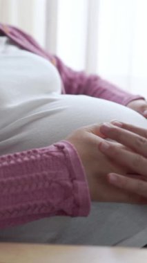 Hamile çift, evde sevgi hisseder ve rahatlar. Hamile bir kadın hamile karnında bebek taşıyor. Baba, hamile anneye göz kulak ol. Annelik ve hamilelik bakımı kavramı.