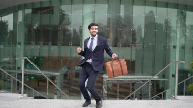 Akıllı iş adamı binanın önünde durmuş ve neşeli bir şekilde dans etmeye başlıyor. Başarılı yatırımcılar terfi almayı, yeni bir pozisyon almayı, satışları arttırmayı, maaşları artırmayı kutlamak için dans ediyor. Sevinçli..