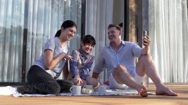 Düğün çifti ve kızı açık terasta piknik yaparken selfie çekiyorlar. Aile, sevgi göstermek için açık hava aktivitelerini kullanır, çocuk ve güçlü aile bağı veya ilişkisi için iyi büyümeyi güçlendirir. Uyumsuzluk.