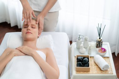 Kafkasyalı kadın stres önleyici kafa masajından ve lüks tatil beldesi ya da otel spa salonundaki modern ışık ortamında yüz güzelliği eğlencelerini şımartmaktan hoşlanıyor. Sessiz.
