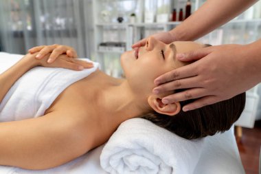 Kafkasyalı kadın stres önleyici kafa masajından ve lüks tatil beldesi ya da otel spa salonundaki modern ışık ortamında yüz güzelliği eğlencelerini şımartmaktan hoşlanıyor. Sessiz.