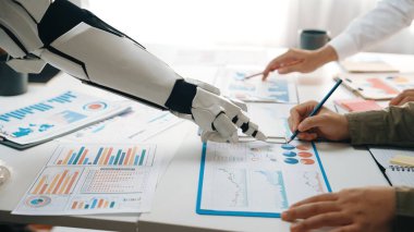 Gelecekçi bir robot el ofiste insan profesyonellerle işbirliği yapar, çizelgeleri ve verileri analiz eder, teknoloji ve takım çalışması arasındaki uyumu gösterir. Noogenesis