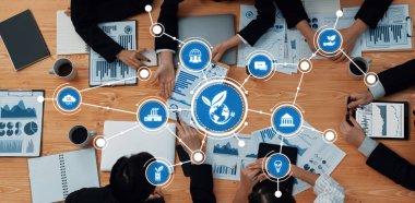 Çevre dostu stratejiler, çizelgeler, grafikler ve üretken tartışmalara katılan profesyonellerin yer aldığı bir iş toplantısının dinamik genel bakış açısı. Dostluk