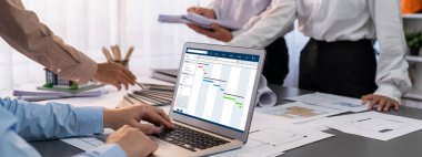 İç mimar tasarımcı grubu, daha kesin tasarım için planlar ve dizüstü bilgisayar ekran mimari yazılımı üzerinde birlikte tartışıyorlar. Modern ev tasarımı ve yenileme. İçgörü