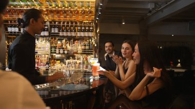 Paloma kokteyli içen güzel bir kadın, lüks tezgah bar arkadaşlığında ve gece kulübünde çift buluşmasında elinde Margarita bardağı ferahlatıcı bir içecek tutan bir arkadaşıyla güzel bir şekilde kadeh kaldırıyor. Vinosity.