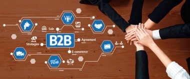 Bu resim, çeşitli ellerin dijital simgeler üzerinde birleşerek modern ticarette anlaşmaları ve stratejiyi sembolize ettiği B2B ortamlarında işbirlikçi bir iş ortaklığını göstermektedir. Dostluk