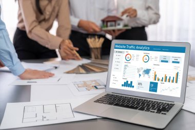 İç mimar tasarımcı grubu, daha kesin tasarım için planlar ve dizüstü bilgisayar ekran mimari yazılımı üzerinde birlikte tartışıyorlar. Modern ev tasarımı ve yenileme. İçgörü