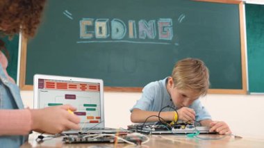 Kafkas akıllı çocuk kök teknoloji dersinde tornavida kullanarak ana tahtayı tamir ederken aynı zamanda gülümseyen öğrenci de dizüstü bilgisayar ekranı kodlu elektronik makineyi incelemek için birlikte çalışıyor. Pedagoji.