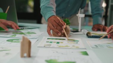 Çeşitli bir ekip, parlak bir ofiste sürdürülebilir bir proje, çizelgeler ve çevre dostu materyaller üzerinde işbirliği yapıyor. Takım çalışmasına ve yeniliğe odaklan. SACTR