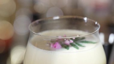 Kapalı tutku meyveleri ve üzerine pembe çiçek eklenerek süslenmiş tatlı likör kokteyli, alkol serinletici vitrin odaklı reklamı için özel yaratıcı içecek menüsü listesi oluşturuyor. Vinosity.