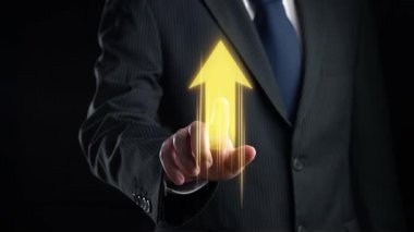 Resmi takım elbiseli bir işadamı, büyümeyi ve yatırım potansiyelini sembolize eden dijital bir finans şeması ve yukarı doğru bir okla karanlık bir zemine karşı duruyor. Dörtgen