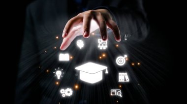 Bir el, eğitim ve yeniliği temsil eden, bilgi, öğrenme ve başarı kavramını modern bir bağlamda gösteren parıldayan dijital simgelere uzanıyor. Dörtgen