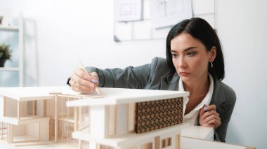 Modern ofisteki ölçü evi model uzunluğuna odaklanan profesyonel güzel mimar mühendisinin yakın çekimi, iç tasarım için yapı oluşturma analizi yapıyor. İş tasarımı. Tertemiz..