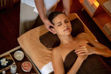 Beyaz kadın stres önleyici kafa masajı yapmaktan ve lüks otel veya otelde sıcak mum ışığında yüz güzelliği eğlencesi yapmaktan zevk alıyor. Sessiz.