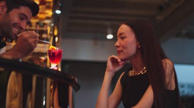 Barmen lüks tezgah barında güzel misafirler için çiçeklerle süslenmiş karışık votka kokteyli servis ediyor. Mükemmel canlı renk sunumu. Atmosfer gece kulübünü ön plana çıkarıyor. Vinosity.