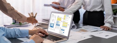 İç mimar tasarımcı grubu, daha kesin tasarım için planlar ve dizüstü bilgisayar ekran mimari yazılımı üzerinde birlikte tartışıyorlar. Modern ev tasarımı ve yenileme. İçgörü