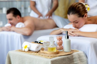 Aromaterapi masajı gündüz atmosferinde ya da spa salonunda bulanık bir kadına odak dekor ve spa aksesuarları kurarak tatil köyünde ya da otel arka planında keyifli aroma spa masajı yapan bir masaj. Sessiz.