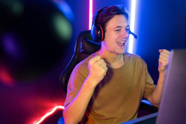 Kazanmak için çevrimiçi oyun oynayan akıllı flama makinesinin sunucu kanalı, neon ışıklı odada seçilen takım yarışması için izleyicilerle birlikte canlı yayında canlı yayında kulaklık takıyor. Bireysel.