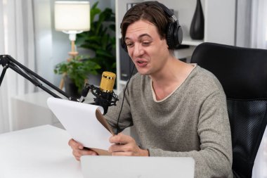 Akıllı yayıncının sunucu kanalı canlı sosyal medya yayını ile dinleyicilere senaryo okuyarak, kulaklık takarak modern ev stüdyosundaki video flamalarını kaydediyor. Bireysel.