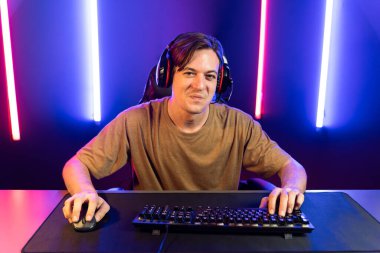 Kazanmak için çevrimiçi oyun oynayan akıllı flama makinesinin sunucu kanalı, neon ışıklı odada seçilen takım yarışması için izleyicilerle birlikte canlı yayında canlı yayında kulaklık takıyor. Bireysel.