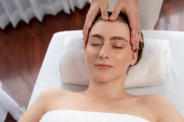 Kafkasyalı kadın stres önleyici kafa masajından ve lüks tatil beldesi ya da otel spa salonundaki modern ışık ortamında yüz güzelliği eğlencelerini şımartmaktan hoşlanıyor. Sessiz.