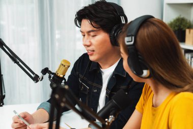 Gülümseyen radyo etkili sunucular, kulaklık takarak sosyal medya kanalından canlı yayın yapıyorlar ve sabah saatlerinde stüdyo kaydında dinleyicilere konu ve dizüstü bilgisayar üzerinden konuşuyorlar. İnfobahn.