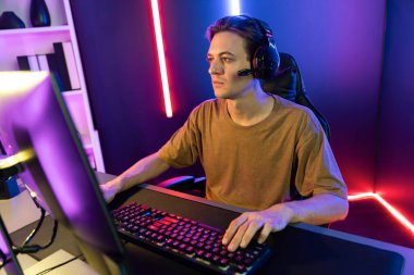 Kazanmak için çevrimiçi oyun oynayan akıllı flama makinesinin sunucu kanalı, neon ışıklı odada seçilen takım yarışması için izleyicilerle birlikte canlı yayında canlı yayında kulaklık takıyor. Bireysel.