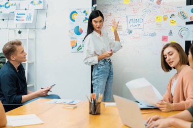 Genç ve güzel lider pazarlama stratejisini sunarken, uzman yatırımcı ve proje yöneticisi de yeni başlayan iş toplantısında iş performansını analiz etmeye çalışıyor. Çok ırklı bir grup. Tertemiz..