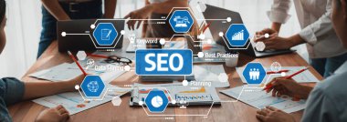 Tahta bir masadaki veri raporları, grafikler ve dijital araçlarla çevrili SEO strateji toplantısına katılan bir ekibin yer aldığı işbirlikçi bir çalışma alanı. Dostluk