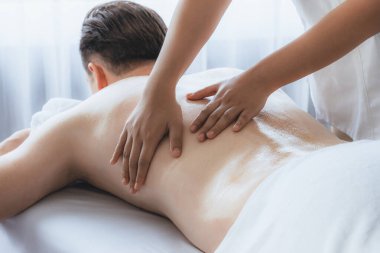 Kafkas erkek müşteri stres önleyici spa masajının keyfini çıkarıyor ve lüks otel veya oteldeki gündüz açık hava ortamında güzellik derisi eğlencesi ile şımartıyor. Sessiz.