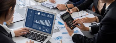 İş zekası ve veri analizi kavramı. Analizci ekibi laptop ekranında finansal veri analizi üzerinde çalışıyor. Etkili iş stratejik planlama için pazarlama göstergesi olarak. İçgörü