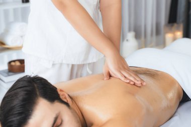 Kafkas erkek müşteri stres önleyici spa masajının keyfini çıkarıyor ve lüks otel veya oteldeki gündüz açık hava ortamında güzellik derisi eğlencesi ile şımartıyor. Sessiz.