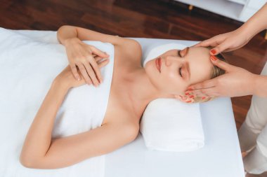 Kafkasyalı kadın stres önleyici kafa masajından ve lüks tatil beldesi ya da otel spa salonundaki modern ışık ortamında yüz güzelliği eğlencelerini şımartmaktan hoşlanıyor. Sessiz.