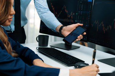 Kâr değeri değeri oranı online web sitesi uygulamasını ev ofisinde analiz etmek için notlar yazan kadınlara telefonda dinamik borsa verilerini gösteren bir işadamı eli kesilmiş. İnfobahn.