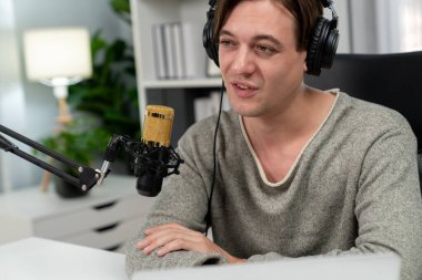 Sunucu kanalı, gülümseyen akıllı yayıncı kaydı, senaryosu ve akıllı telefonuyla sosyal medyada sohbet programı, kulaklık takarak modern ev stüdyosundaki video flamalarını kaydediyor. Bireysel.