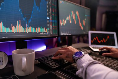 Akıllı tüccar işadamlarının elleri dinamik borsa yatırımlarına yoğunlaşarak bilgisayar ve dizüstü bilgisayara odaklanarak karanlıkta neon ışıklı ofisteki arama pazarında yüksek kar elde ettiklerini gösteriyor. Tahmin et..