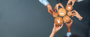 Bu resim, iş dünyasındaki işbirliğini ve takım çalışmasını simgeleyen ahşap dişlileri tutan çeşitli elleri tasvir ediyor. Profesyonel ortamlarda strateji ve yeniliklerle ilgili kavramlar için idealdir. Dostluk