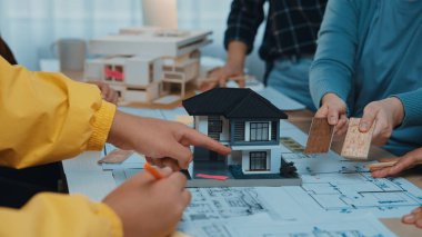 Bir takım, bir mimari projede işbirliği yaparak bir model ev, planlar ve materyal örnekleri sergiliyor. Sahne tasarımda yaratıcılığı ve takım çalışmasını gösteriyor. SACTR
